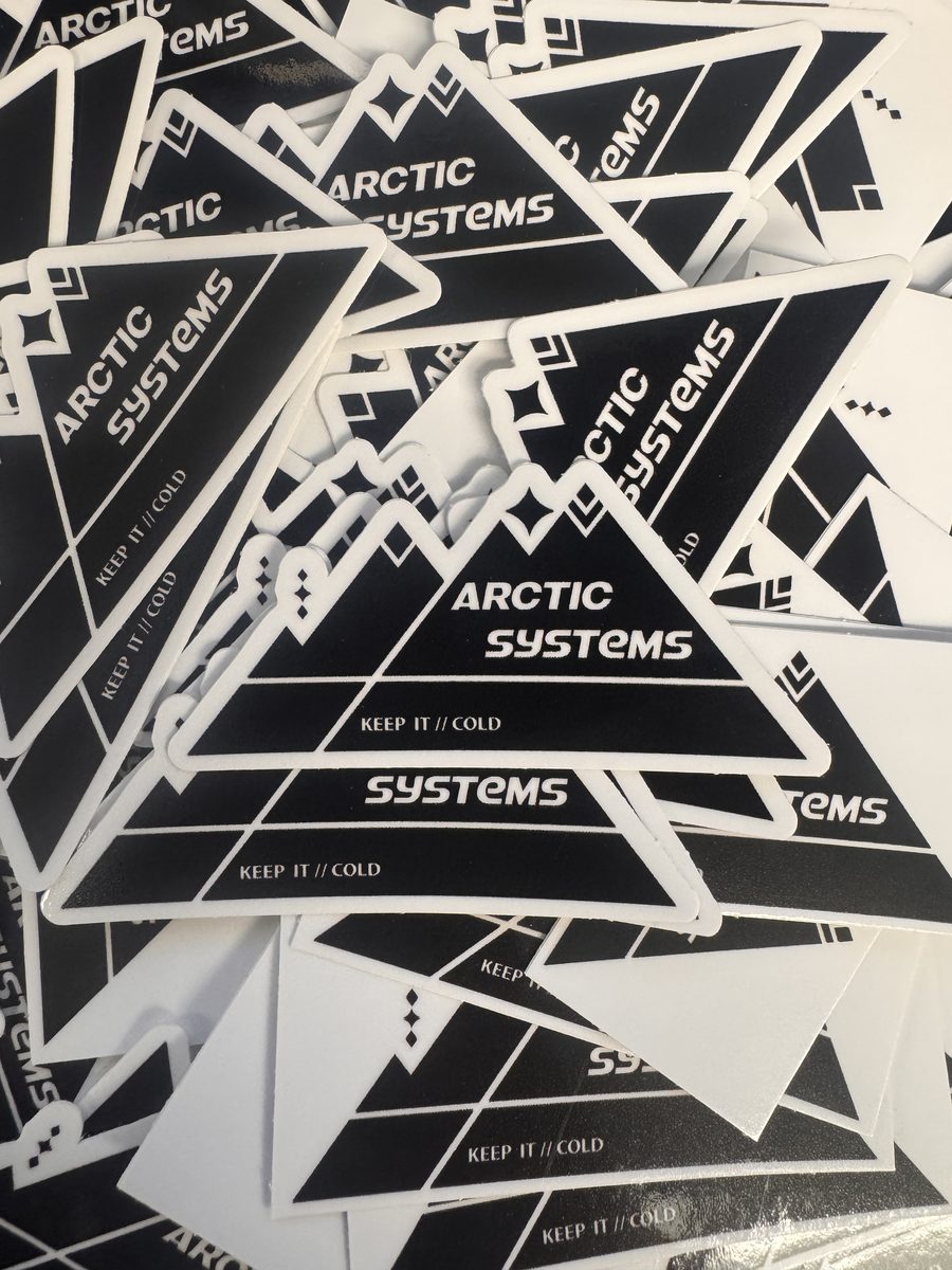 A stack of Arctic Systems black and white mountain-logo stickers